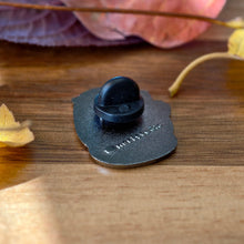 Raccoon holding acorn enamel pin